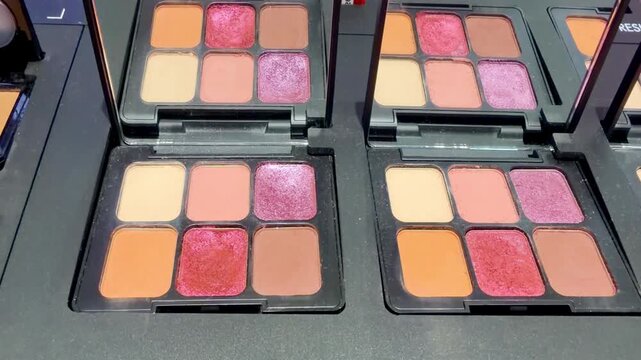Eyeshadow and Blush Palettes on Display in Cosmetics Store &ndash; Colorful Makeup Products on Shelf