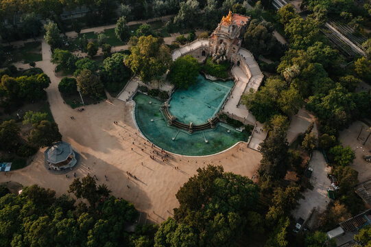 Aerial view of the Cascada Monumental fountain with its turquoise pool and golden sculpture surrounded by lush trees and pathways in Barcelona, Catalonia, Spain.