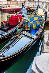 gondolas in venetian canal decorated in traditional vintage style of Venice and old architecture buildings on background © Yaroslav