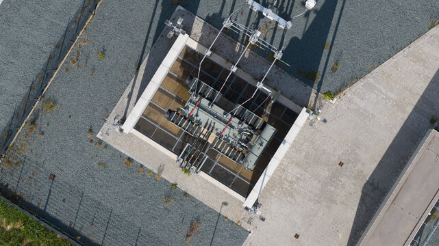 Aerial view of the Westermeerdijk electrical substation featuring high-voltage transformers and metal infrastructure set on a gravel surface in Espel, Flevoland, Netherlands.