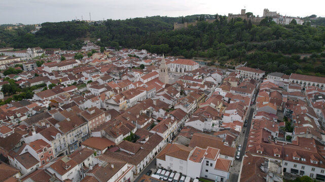 Aerial view of the historic town of Tomar with red-tiled rooftops, narrow streets, and the Convent of Christ overlooking the landscape in Tomar, Santarem District, Portugal.