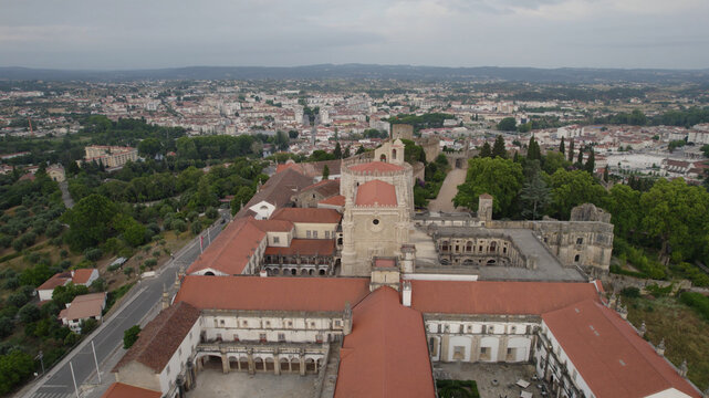 Aerial view of the historic Convent of Christ with its distinctive red-tiled roofs and stone architecture, overlooking the town of Tomar, Santarem, Portugal.