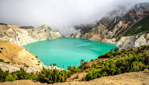 Stunning turquoise crater lake with sulfur steam and rugged mountains in Indonesia, breathtaking natural landscape