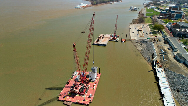 Crane barge lifting equipment beside Paducah riverfront