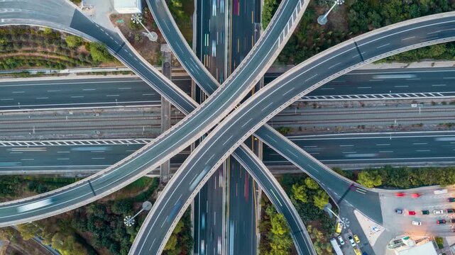 Aerial overhead timelapse view of a highway interchange with flyovers, crossroads and car traffic as a urban transport concept