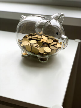 Transparent Glass Piggy Bank Filled with Gold Coins