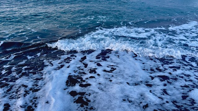 Crashing waves and white foam on shore of the Mediterranean Sea