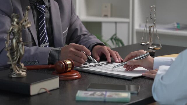 Female Client Submitting Case Files and Envelopes to Attorney During Legal Consultation in Law Firm