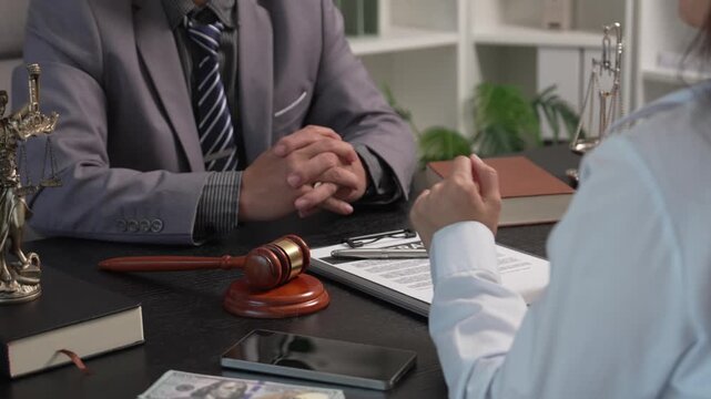 Female Client Submitting Case Files and Envelopes to Attorney During Legal Consultation in Law Firm
