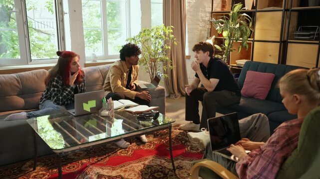 Diverse creative team exchanges opinions around coffee table at modern loft workspace thoughtful attention. Creative teamwork, project planning, remote collaboration concept