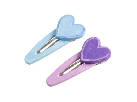 Two pastel hair clips with painted heart shapes isolated on transparent background