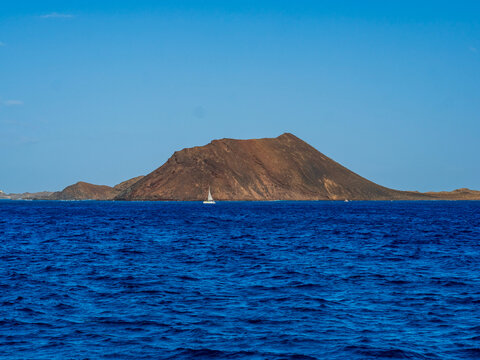 Rocky island rising from a calm blue sea