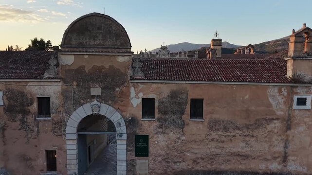 Old arched gateway and weathered walls of the Carthusian monastery of Padula in the evening light, Salerno, southern Italy