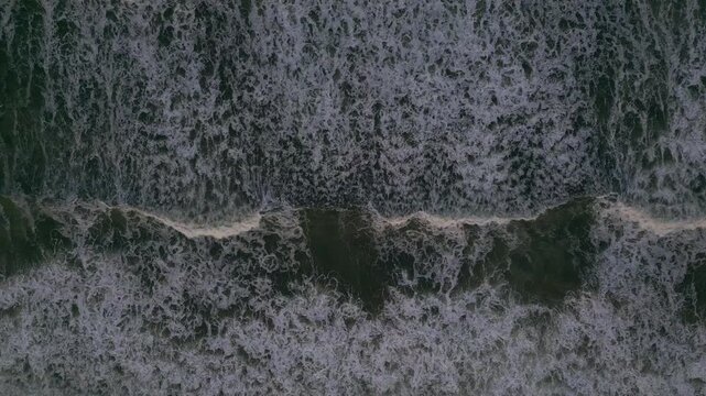 Top Down Aerial View of Dark Sea Water with White Foamy Waves