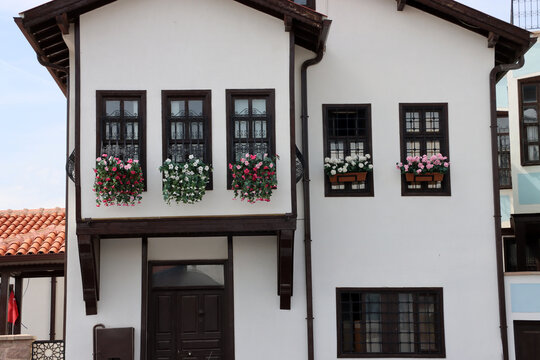 Close-up views of Konya houses restored a few years ago. Colorful flowers adorn the windows of these traditional Turkish houses. Konya, Turkey.