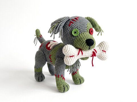 Crochet zombie dog with button eye carrying bone