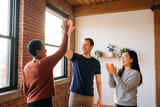 Coworkers High Five in Loft Office Celebration