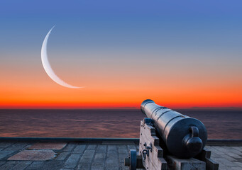 Ramadan kareem Concept - Ramadan kareem cannon with crescent - Night sky with moon in the clouds at sunset © muratart