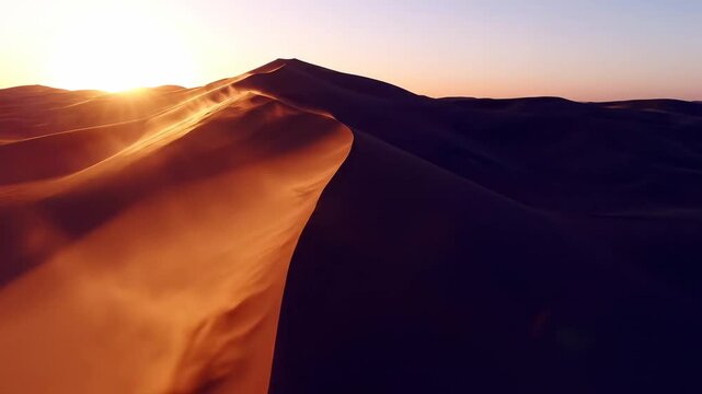 Golden sand dunes are visible in the desert during sunset. The sun