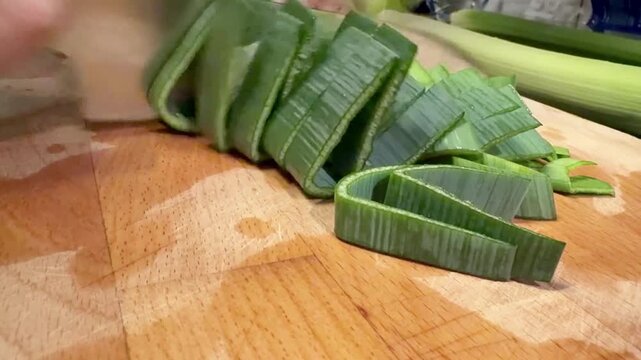 Slicing Fresh Leek Into Rings on a Wooden Board