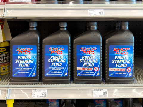 Aubrey, Texas, USA - September 22nd, 2026: Black Shop Pro power steering fluid bottles lined up inside AutoZone store
