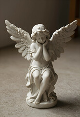 Fototapeta premium Spirituality and peace marble angel statue with wings in a contemplative pose for funeral memorial and religious themes in a quiet indoor setting