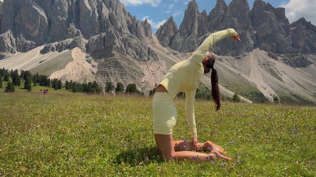 Woman Doing a Kneeling Backbend Yoga Stretch in the Dolomites