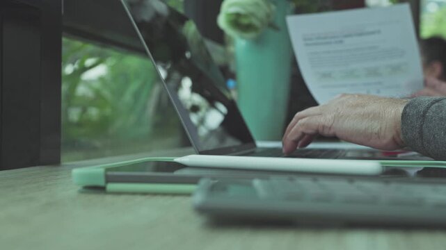 Senior analyst conducts financial audit tasks, reviewing audit sheet alongside computer data while managing audit procedures during investment planning.