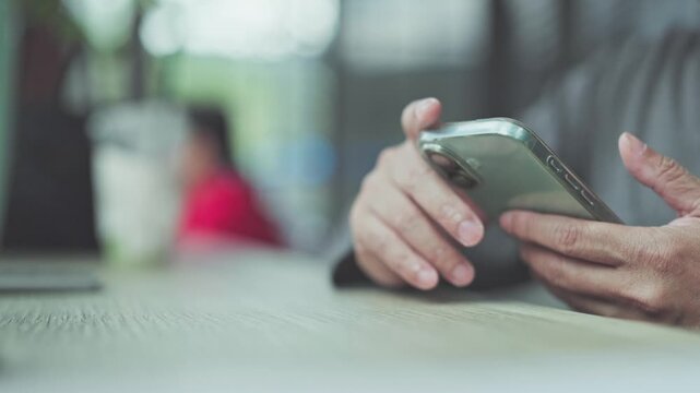 Messaging colleague during work, person holding mobile device reviews messaging thread before work schedule update messaging alert.
