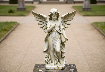 Fototapeta premium Spirituality and peace stone angel statue in a garden religious faith and hope memorial and cemetery art classic sculpture in a public park setting