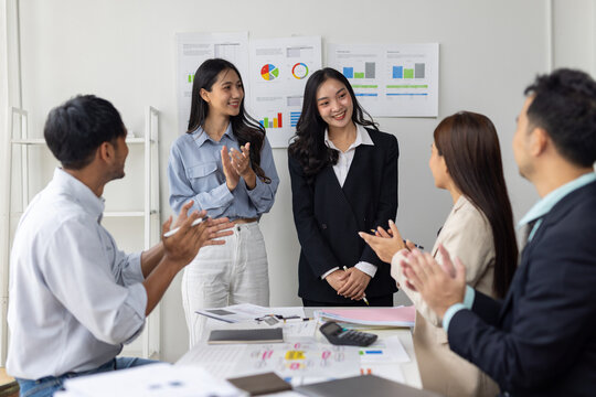 Business team welcoming new colleagues during office meeting. Business professionals congratulating and applauding new team members joining an office meeting for introduction and welcome.