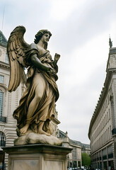 Fototapeta premium Spirituality and religion concept, stone angel statue standing in a historic city center with classical architecture and urban street background