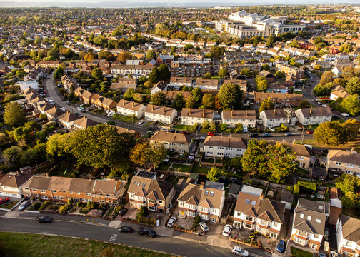 Aerial shot of a quiet English suburban neighborhood at sunset.