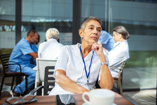 Senior healthcare worker thinking during coffee break outside hospital