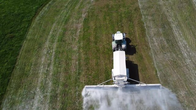 Aerial Top Down View of Tractor Spreading Agricultural Lime Across Grassland in Austria