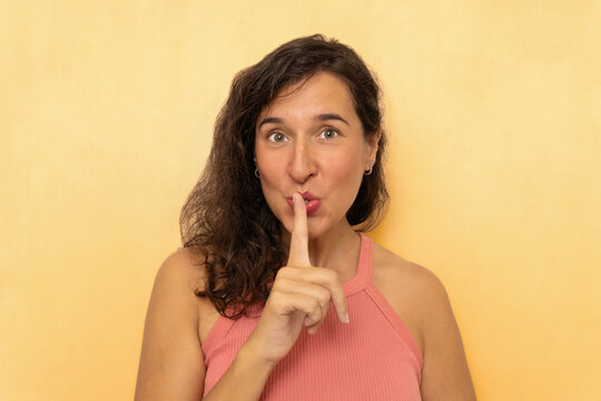 Woman shushing keeping a secret with finger on lips
