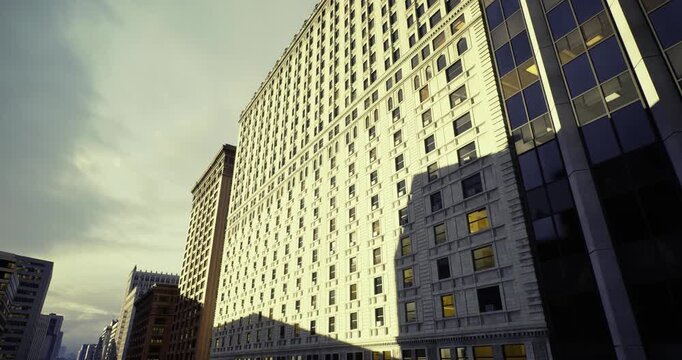 repetitive window patterns on sunlit facade, rhythmic grid composition, detailed glass reflections and geometric repetition across modern highrise
