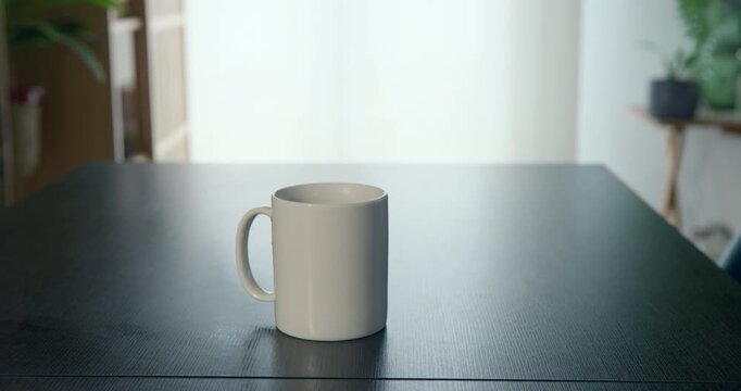 Simple White Mug on Table: A clean, empty white ceramic mug rests on a dark, reflective table, its handle invitingly poised. Soft, natural light illuminates the scene.