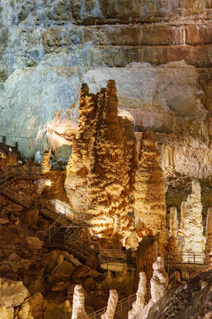 Stalactites and stalagmites in a cave Grotta di Monte Cucco in Umbria, Italy. Brown stones and crystalline deposits jut upwards.