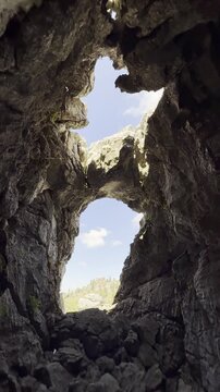 Unique geological rock formations and natural cave window framing the majestic Taurus mountain range
