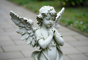 Fototapeta premium Spirituality and peace stone angel statue with praying hands in a garden religious faith and hope memorial sculpture for cemetery or church yard