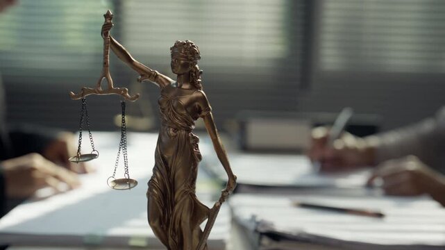 Lady Justice Statue with Scales in Law Office During Legal Consultation
