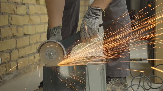  a worker cutting a square galvanized ventilation pipe with an angle grinder