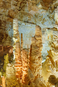 A rock formation in a cave Grotta di Monte Cucco in Umbria, Italy. The formation consists of rod-like structures protruding upwards. It is light brown in color.