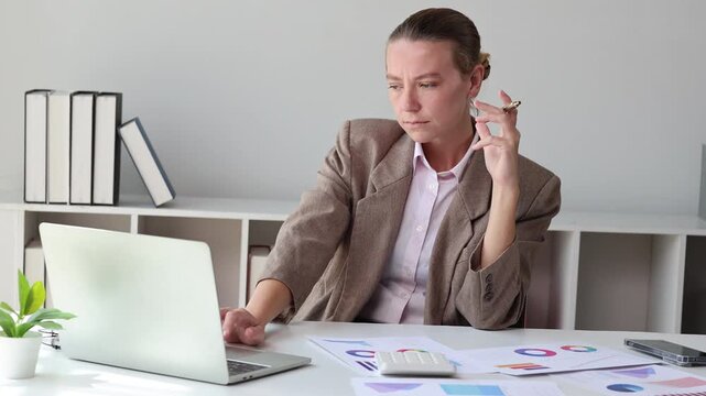 Frustrated businesswoman working on a laptop computer having problem with a project in the office