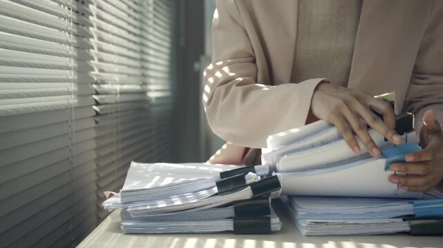 Overworked Businesswoman Managing Heavy Paperwork and Document Overload in Office