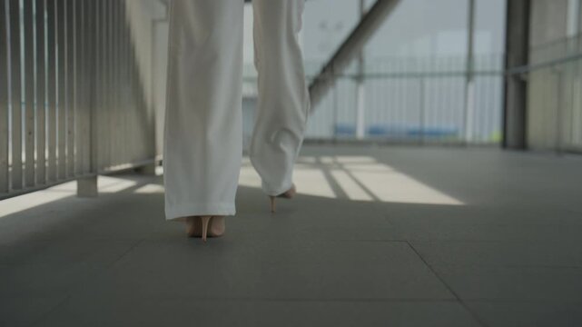 Businesswoman Walking Through Modern Office Corridor in Professional Attire