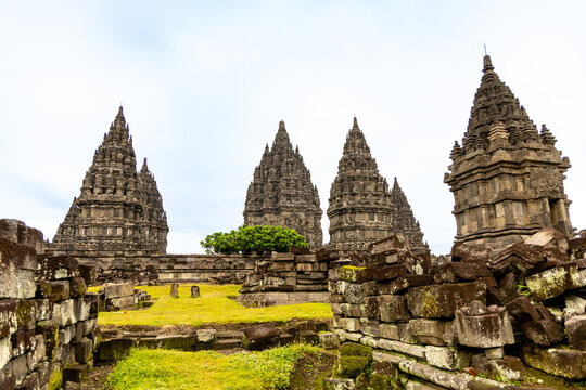 Prambanan Temple in Central Java, Indonesia. A vast 9th-century Hindu temple complex with intricate stone spires, sculptures, and ancient ruins under a cloudy sky.