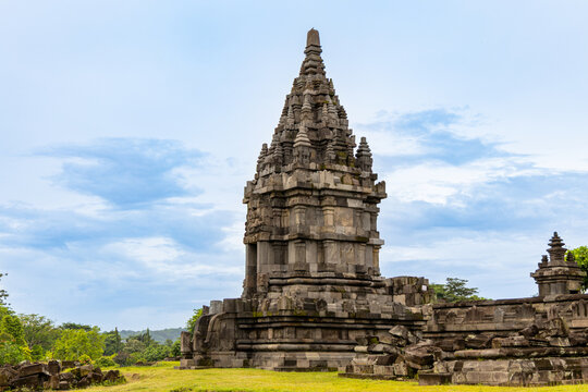 Prambanan Temple in Central Java, Indonesia. A vast 9th-century Hindu temple complex with intricate stone spires, sculptures, and ancient ruins under a cloudy sky.