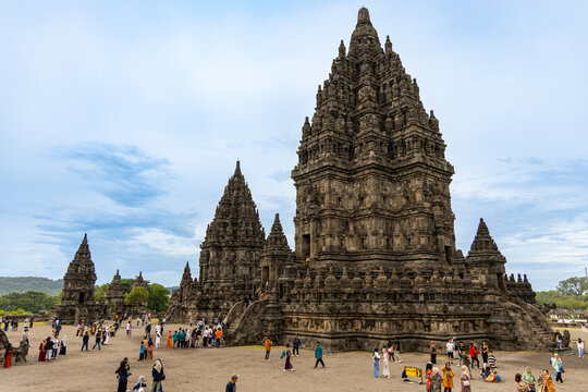 Prambanan Temple in Central Java, Indonesia. A vast 9th-century Hindu temple complex with intricate stone spires, sculptures, and ancient ruins under a cloudy sky.